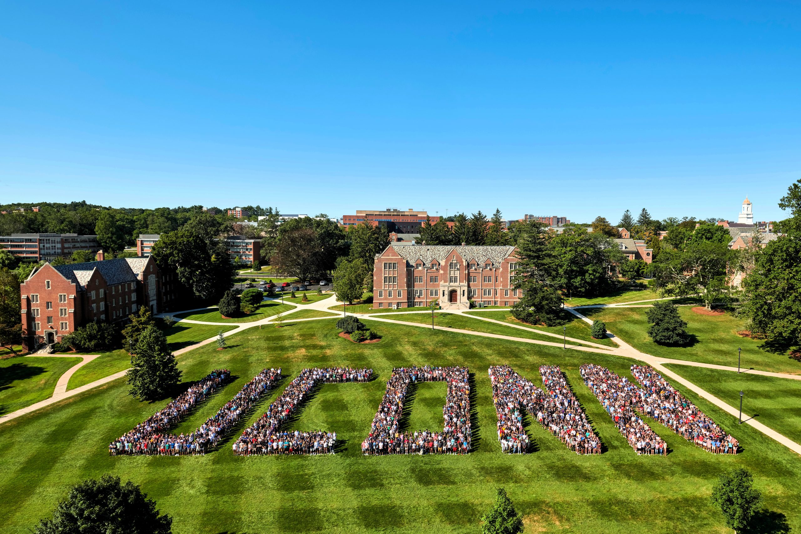 Class of 2023 line up on Storrs great lawn and spell out U-C-O-N-N (uconn)